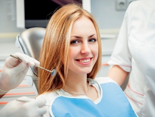 Young blonde woman smiling in dental chair