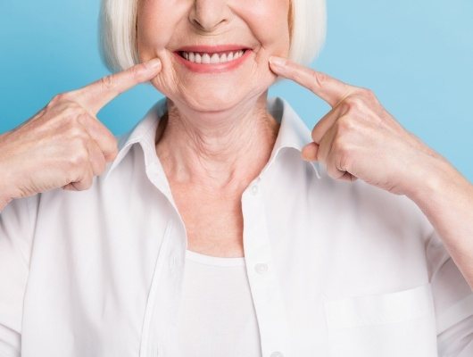 Close up of senior woman pointing to her smile
