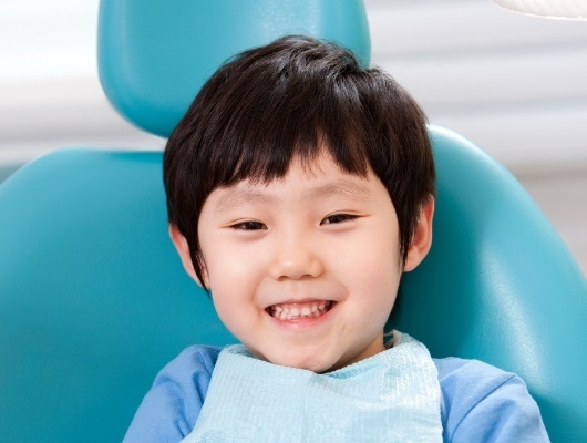 Young boy grinning in dental chair