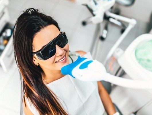 Woman getting her teeth professionally whitened in dental office