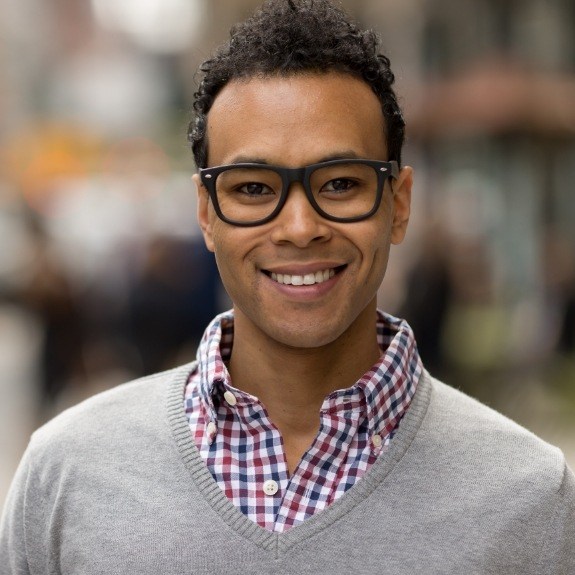 Man in gray sweater and glasses smiling after dental implant failure and salvage in Denton