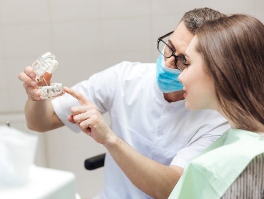 Dentist showing a dental implant to a patient