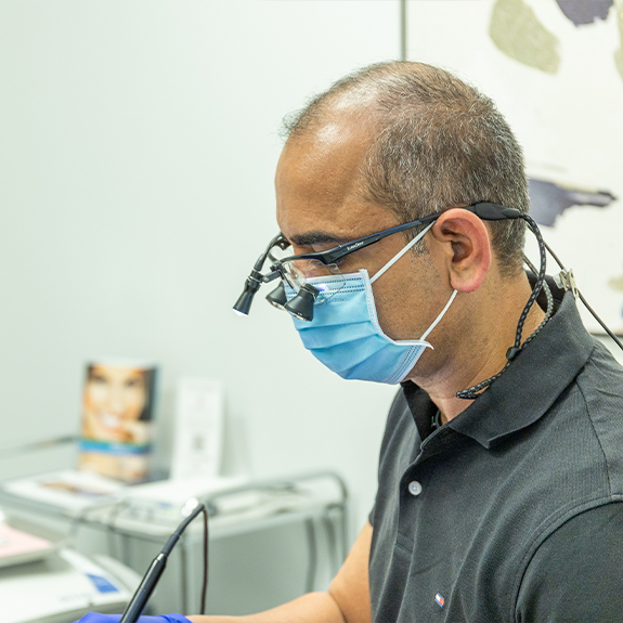 Doctor Ahir examining a patient with dental implants in Denton
