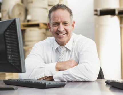 Older businessman sitting at desk with computer