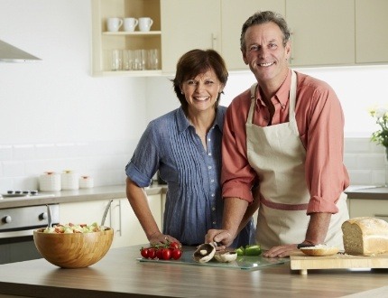 Man and woman chopping vegetables in their kitchen