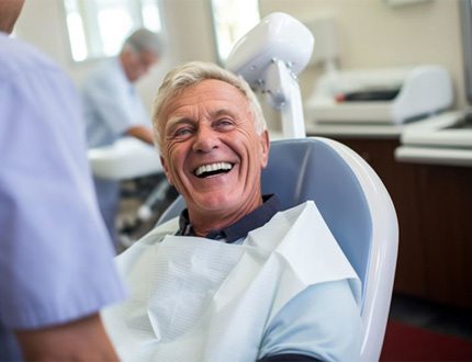 Happy older man in dental treatment chair