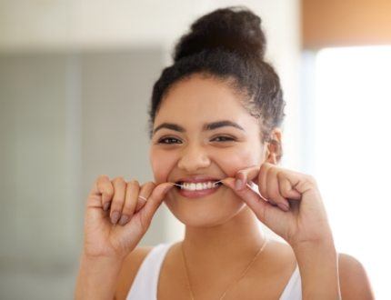 Woman flossing her teeth