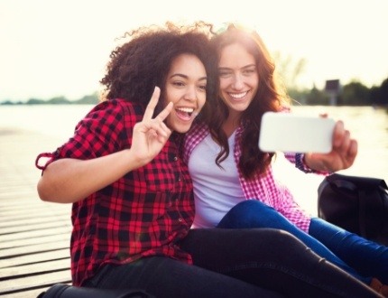 Two women taking selfie with lake in background