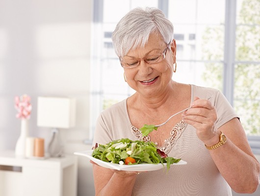 Woman with dentures eating a salad