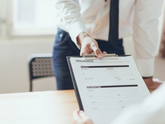 Person looking at dental insurance paperwork on clipboard