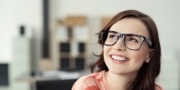 Smiling young woman with brown hair and glasses