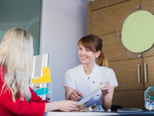 Dental team member showing pamphlet to a patient