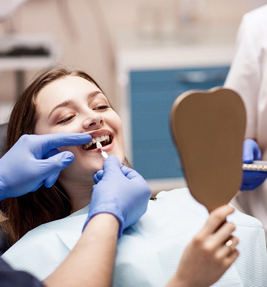 A dentist preparing a woman for a smile makeover