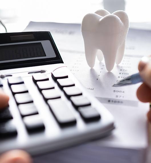 An off-screen patient calculating the cost of their dental care