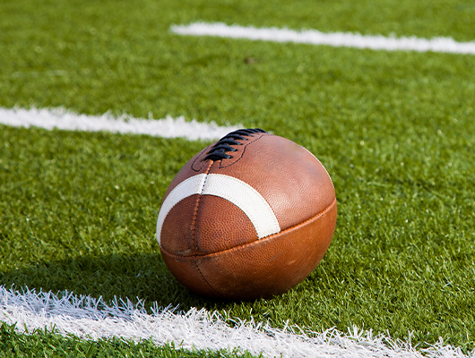 Close up of football laying on grass