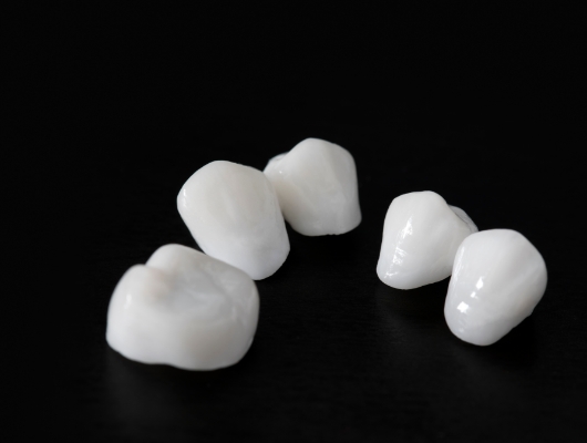 Several dental crowns against black background