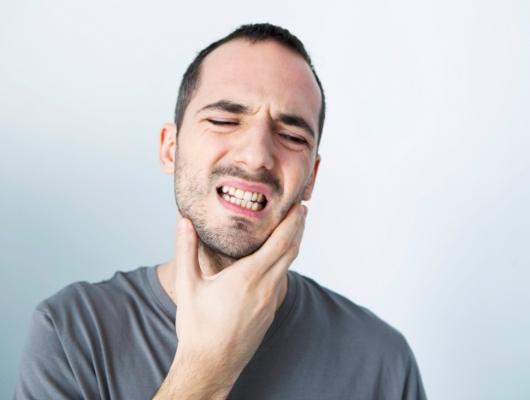 Man touching his lower jaw in pain