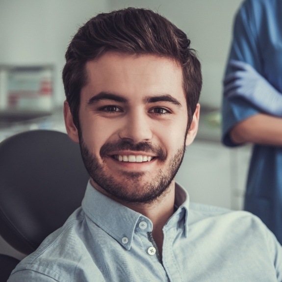 Man smiling in dental chair before oral cancer screening in Denton