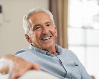 Smiling senior man resting his arm across back of couch