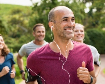 Smiling man running and wearing earbuds