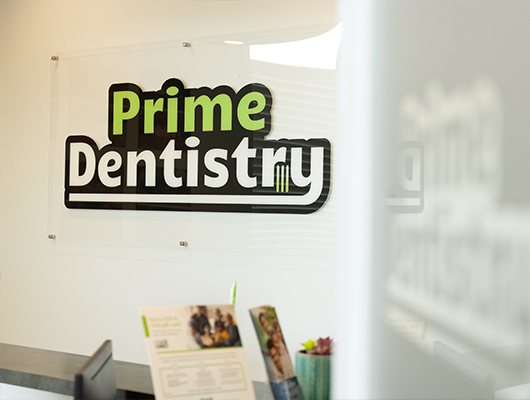 Prime Dentistry sign on wall behind front desk