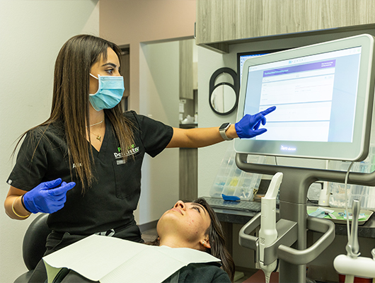 Dental team member touching computer screen during dental checkup