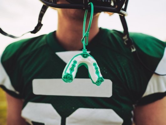 Athletic mouthguard hanging from football helmet