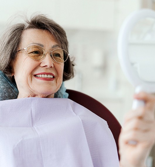 Man in denim jacket smiling with arms folded