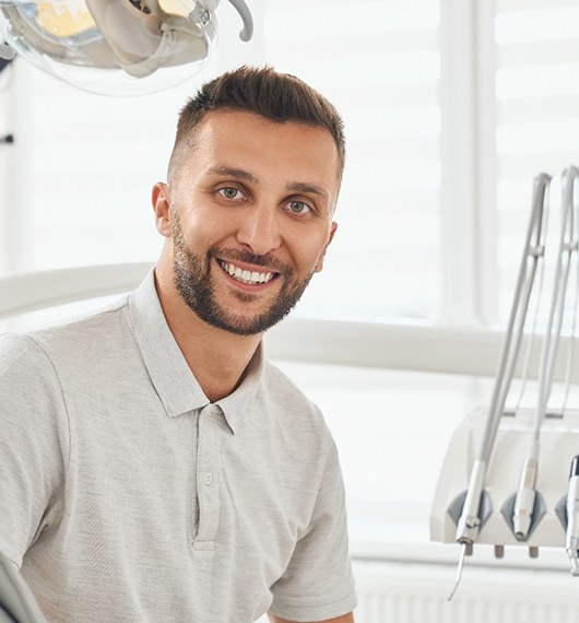 Senior female patient checking smile in handheld mirror