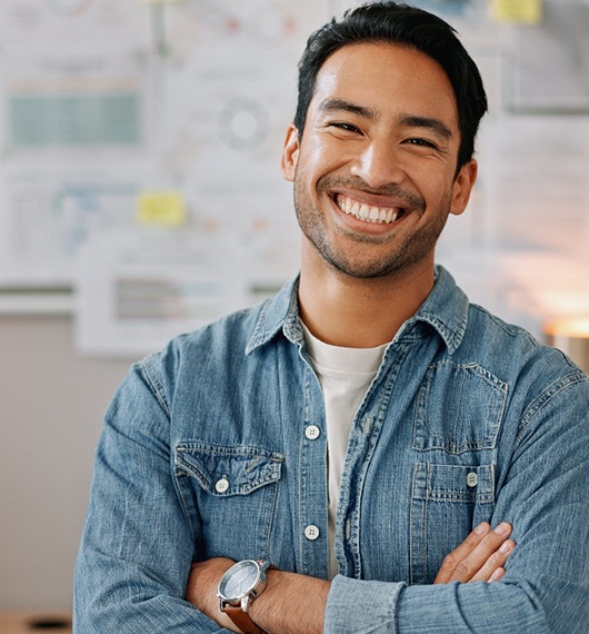 Man in white shirt sitting and smiling in dental chair