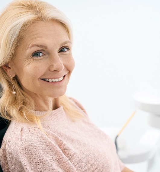 Older woman sitting in dental chair smiling