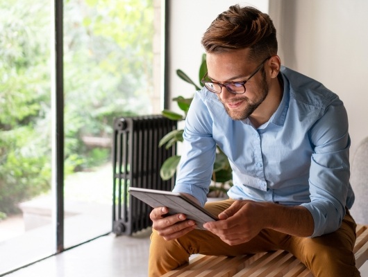 Young man with glasses looking at tablet