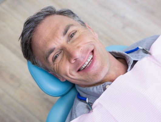 Man in dental chair grinning