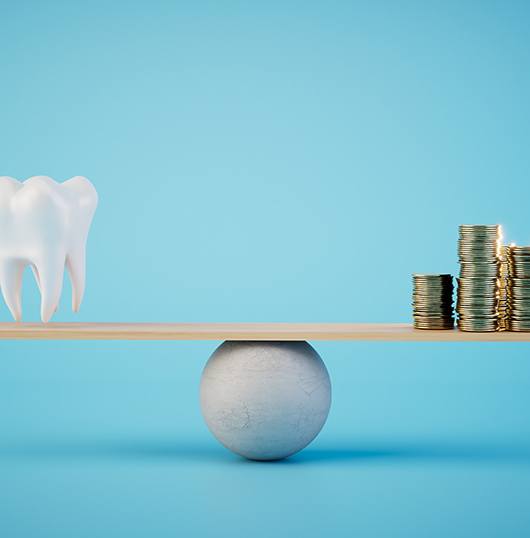 A balance beam holding a large model tooth and stacks of gold coins