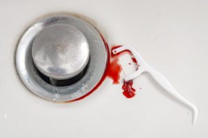 a dental floss pick with blood on it sitting in a sink