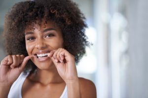 woman following oral hygiene tips by flossing 
