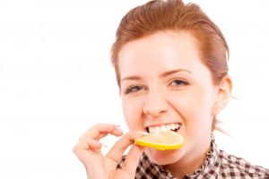 woman eating a lemon slice