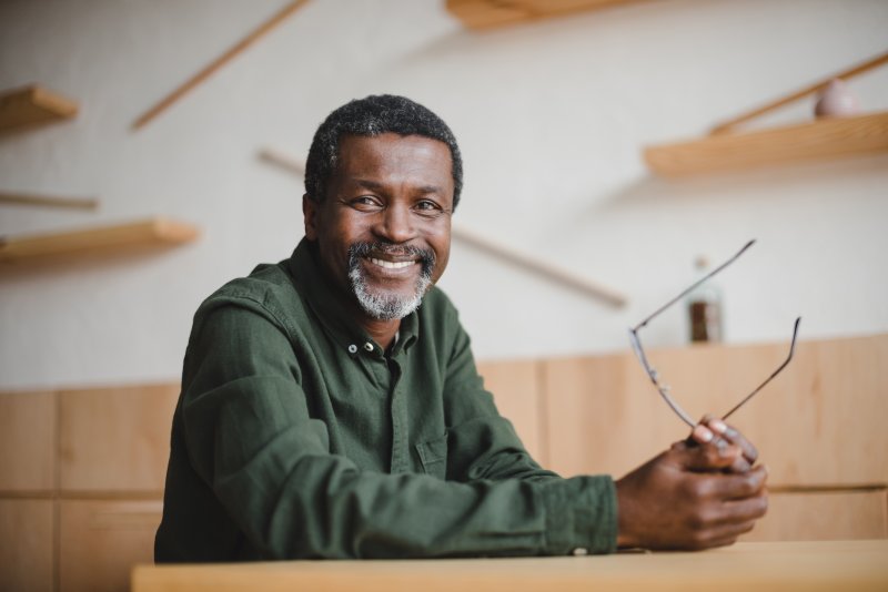 man smiling while sitting on table 