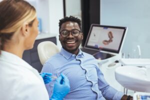 Patient smiling and talking to dentist.