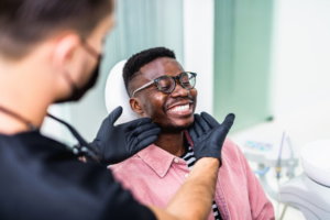 Patient smiling as dentist checks his teeth